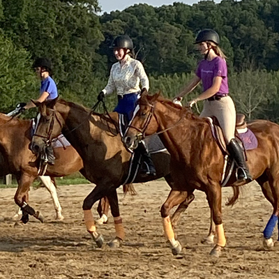 camp participants in riding in a pasture