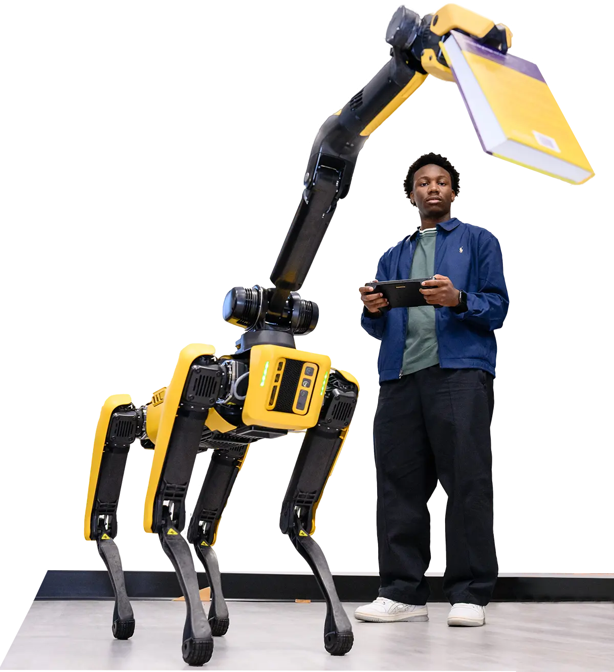 A student operates a quadrupedal robot via remote control in a classroom 