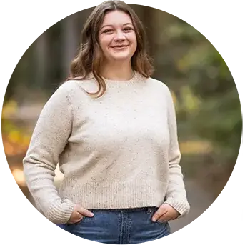 A female grad student poses in a Grey polo that reads deep orange