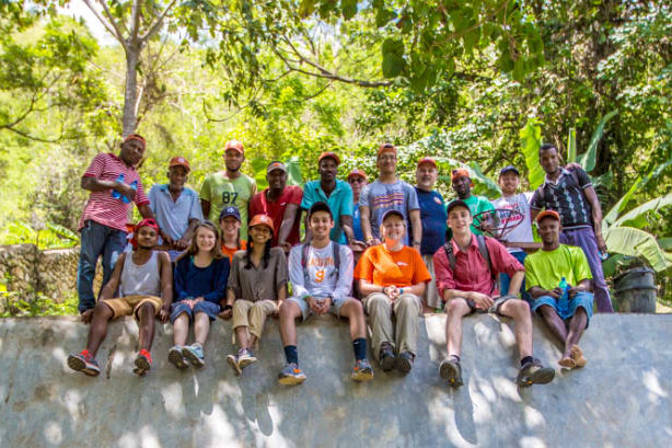a group of students pose with locals at a project site in Costa Rica