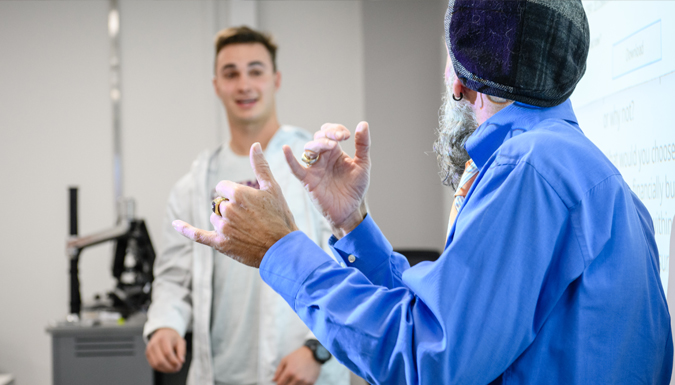 asl instructor signing and looking at a male student