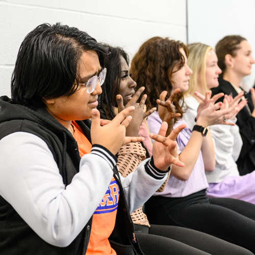 a group of students practicing American Sign Language