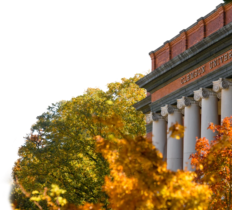 Sikes Hall rises above orange and green-leafed trees. 