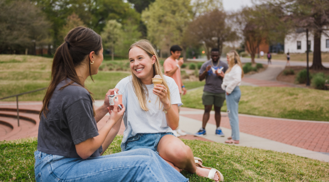 Students smile and talk while eating ice cream outside of The '55 Exchange.