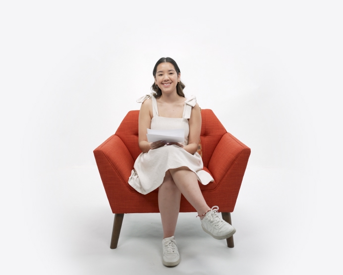 student sitting in a chair reading a letter