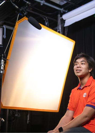 Nam Huynh speaks during an interview in the video studio with a microphone overhead.