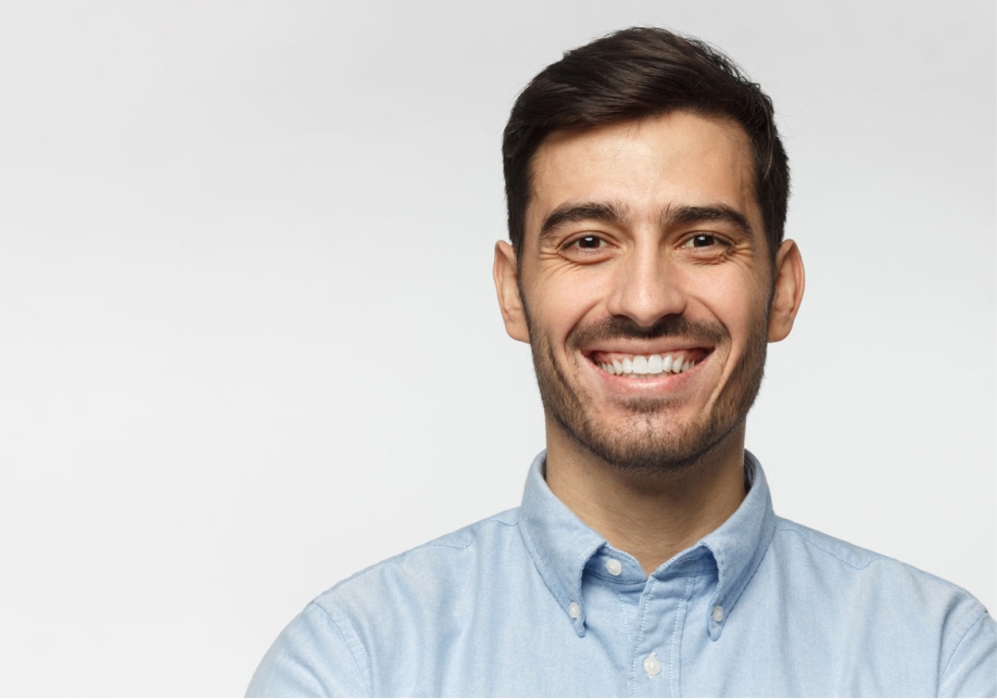 Headshot of a smiling man looking directly at the camera with a plain white background. 