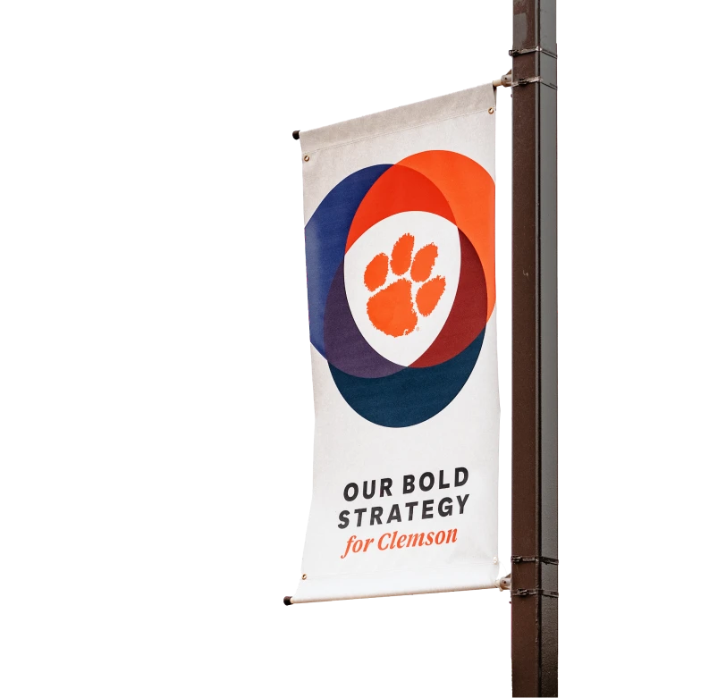 A Clemson Elevate banner hanging from a black light post.