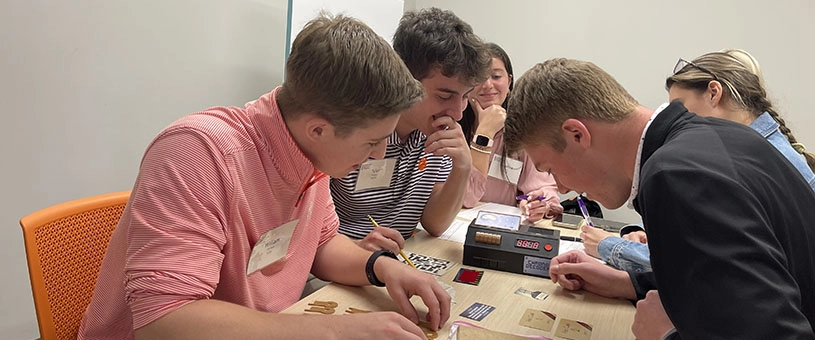 Students working together at table in campus setting.