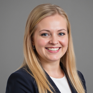 Professional headshot of a smiling woman with long blonde hair wearing a dark blazer.