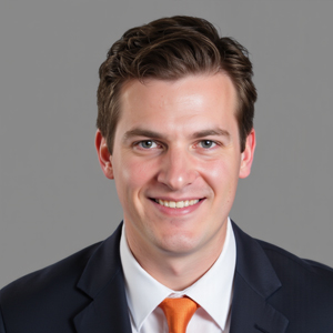 Professional headshot of a smiling man in a dark suit with a white shirt and orange tie.