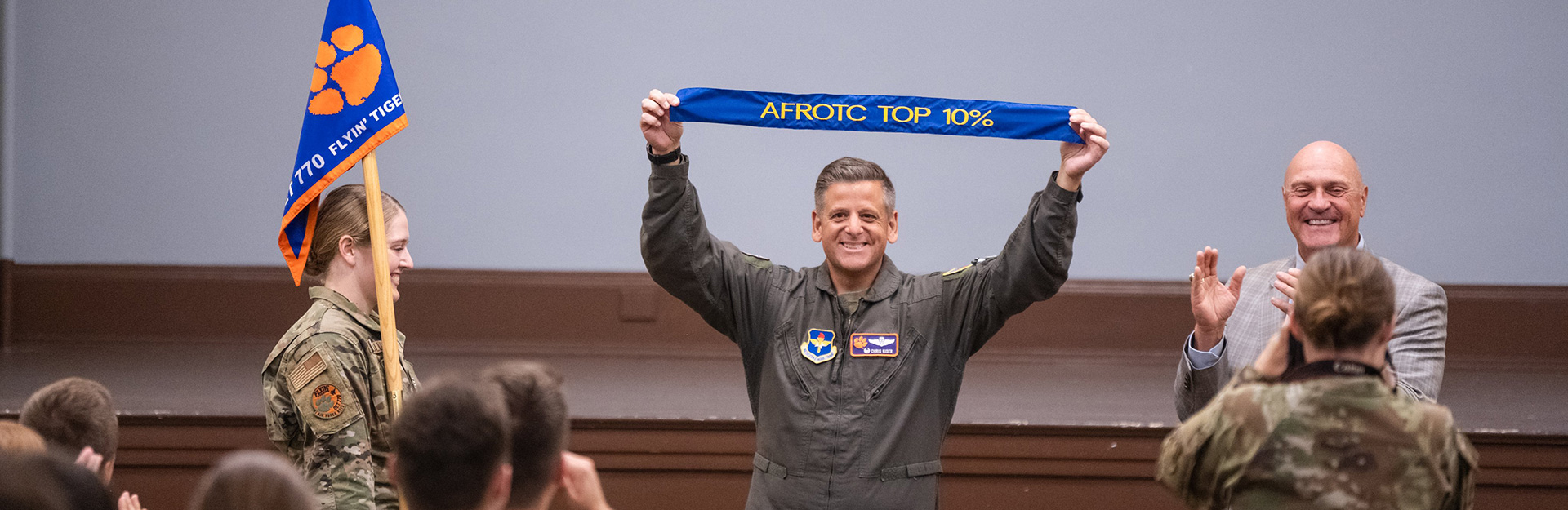 Man in flight suit holding banner