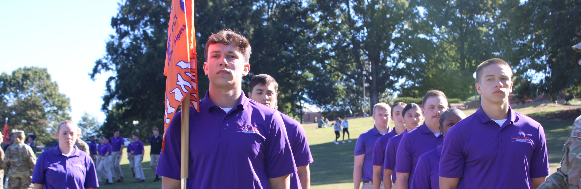 Cadets standing together in purple shirts and khakis.