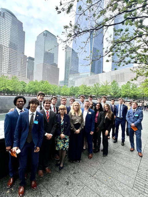 Group of students standing in front of tall buildings in the city.