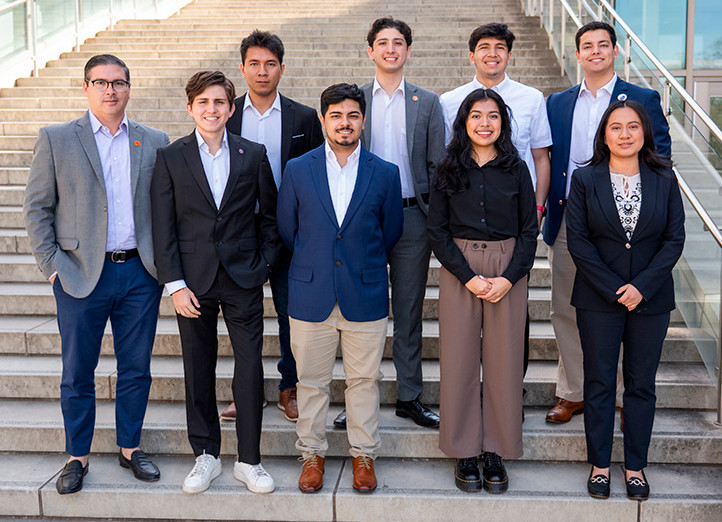 Group of young professionals posing on outdoor steps, dressed in business attire.