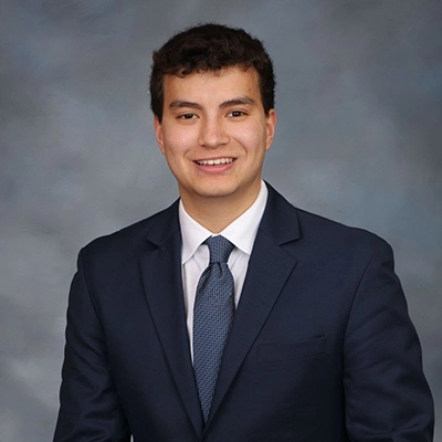 Professional headshot of a young man in a suit and tie.