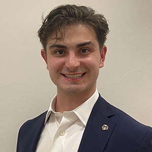 A smiling young man in a suit, projecting confidence and professionalism.