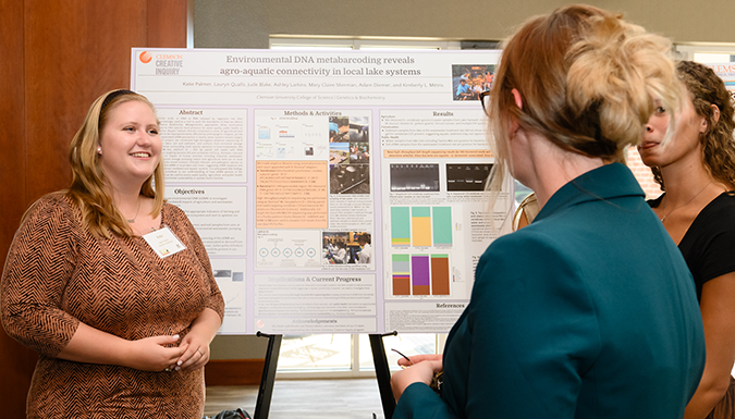 student presenting a research poster