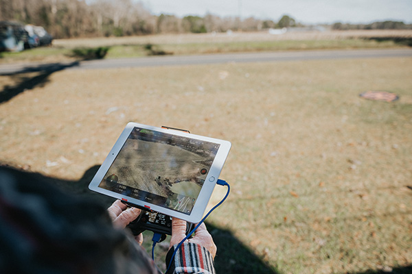 person on a field looking at a drone screen