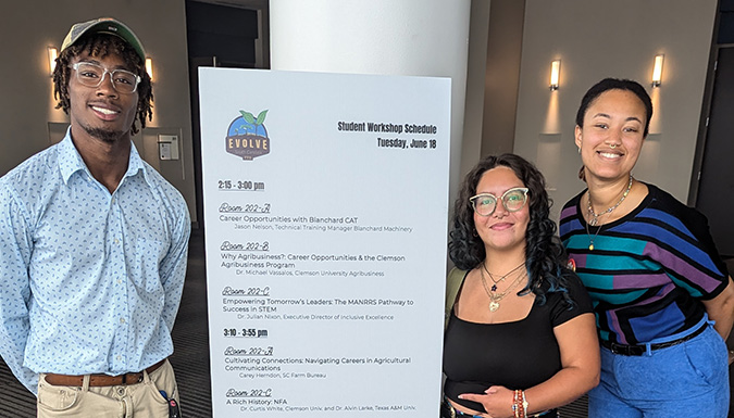 Manrrs students posing in front of a sign at the conference