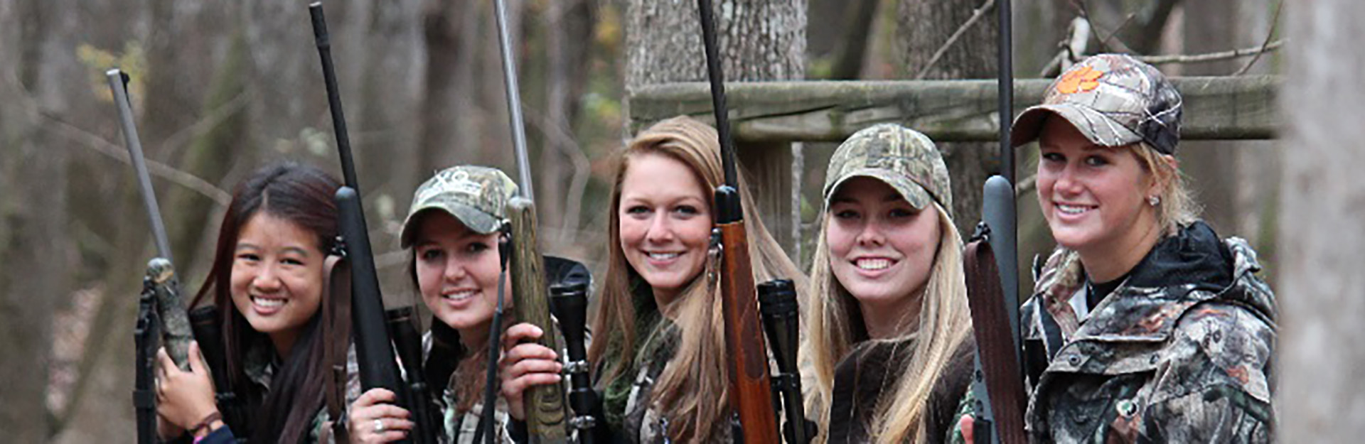 Student in the forest holding rifles