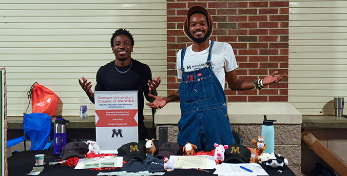 2 students presenting at a stand