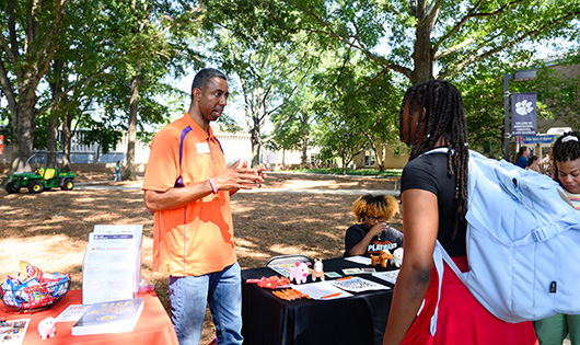 students interacting with Julian at a stand