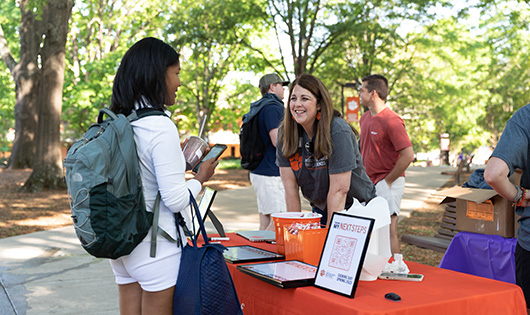 student talking to Paula Beecher at a stand