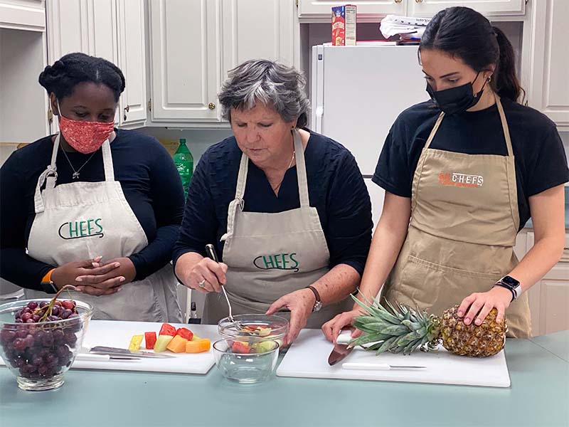 students and professor preparing food