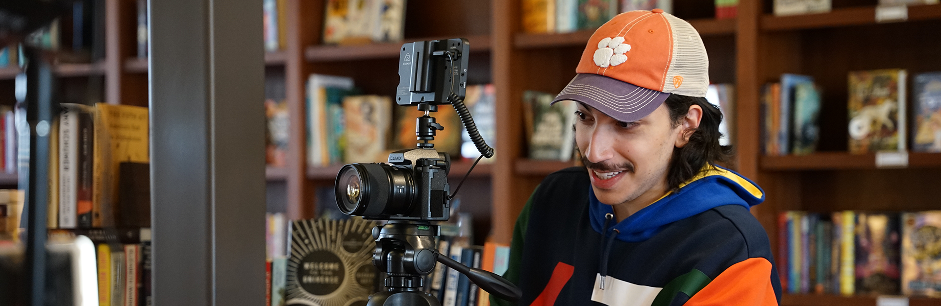 A person with a camera wearing a Clemson hat