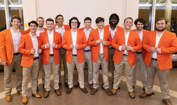 Members of Tigeroar pose in orange jackets