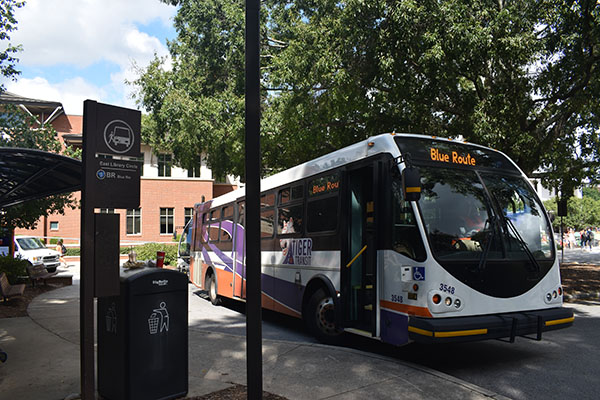 Example campus route bus which is white with purple tiger stripes.
