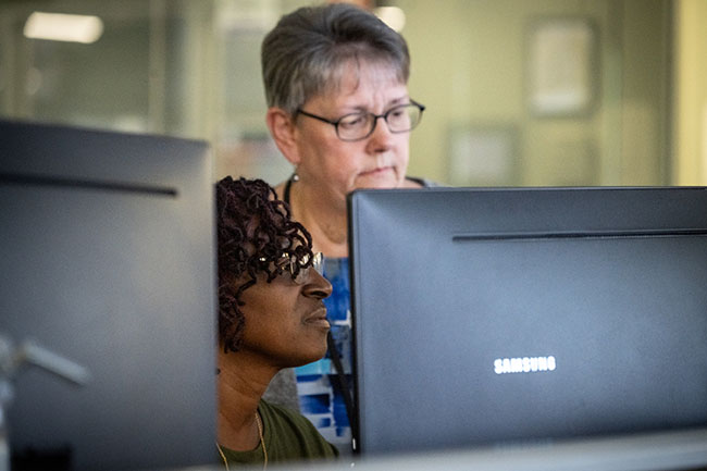 Two CCIT employees looking at a computer monitor together