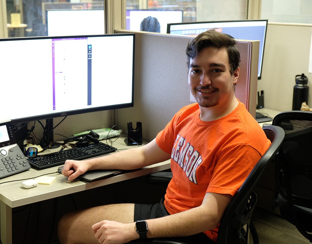 A CCIT student working diagnosing an issue with a laptop while communicating with a student.
