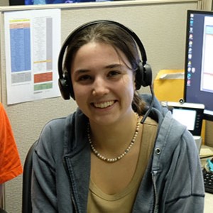 Headshot of Ella, sitting at a desk in the help center.