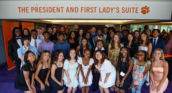 A group of students poses together under a sign that reads "THE PRESIDENT AND FIRST LADY'S SUITE."