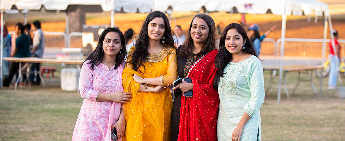 Four young women attend the International Festival wearing traditional saris.