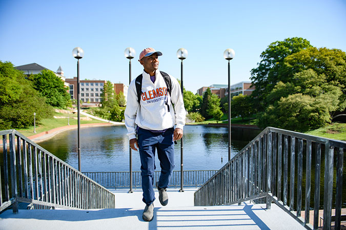 Student walking confidently up library bridge stairs