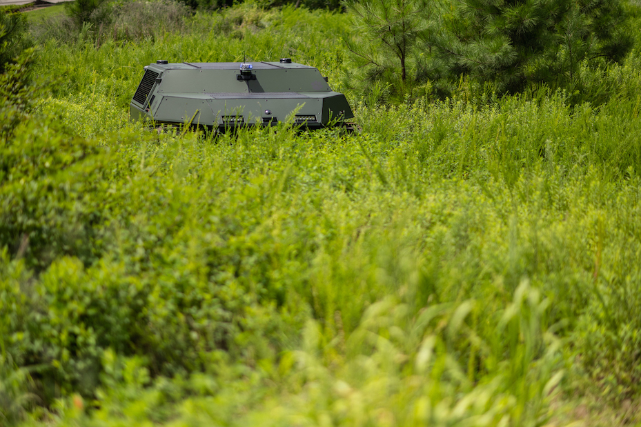 DO14 vehicle traversing through a field thick with growth