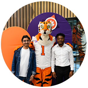 Duvall standing with another student mentee and the Clemson tiger mascot.