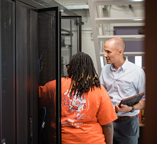 Student and faculty in server room on campus