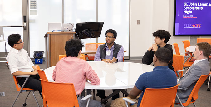Students gathered at table at scholarship night event.