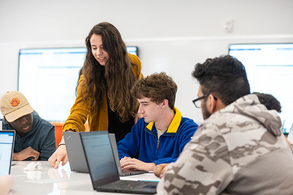 General Engineering students in class with teacher assisting