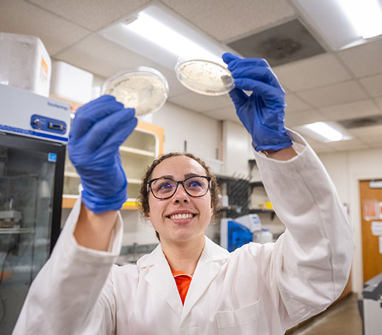 Student holding up samples in lab