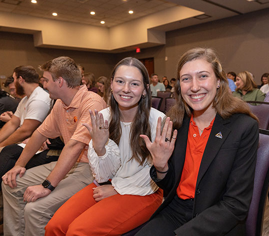 Two students showing their rings at Order event.