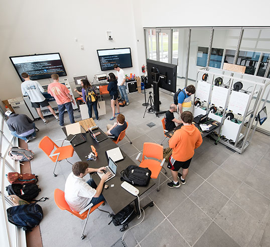 Makerspace room with students working at various stations.