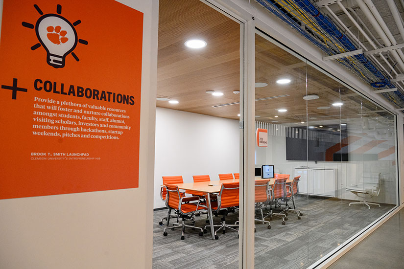 Looking inside room at Launchpad hub, with sign in hallway talking about collaboration.