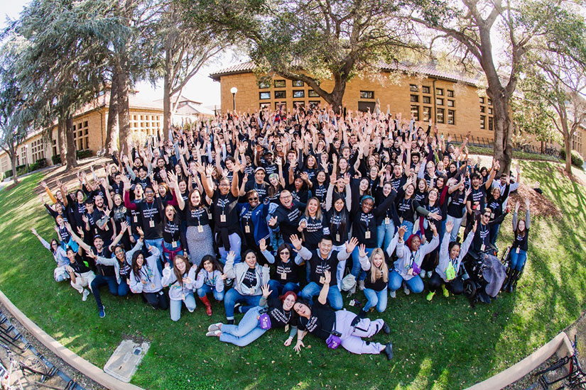 Large group of students on lawn wearing shirts with the words University Innovation Fellows.