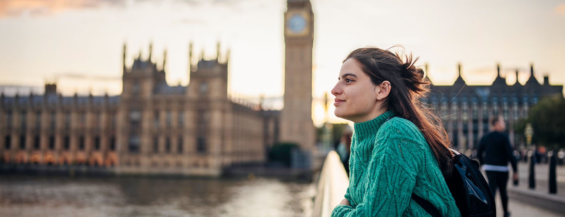 Female student admiring the city of London on the Westminster bridge next to Big Ben.