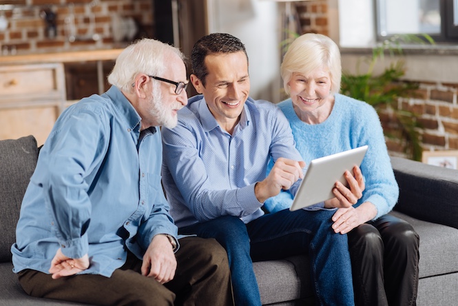 Three people on a couch reviewing a document